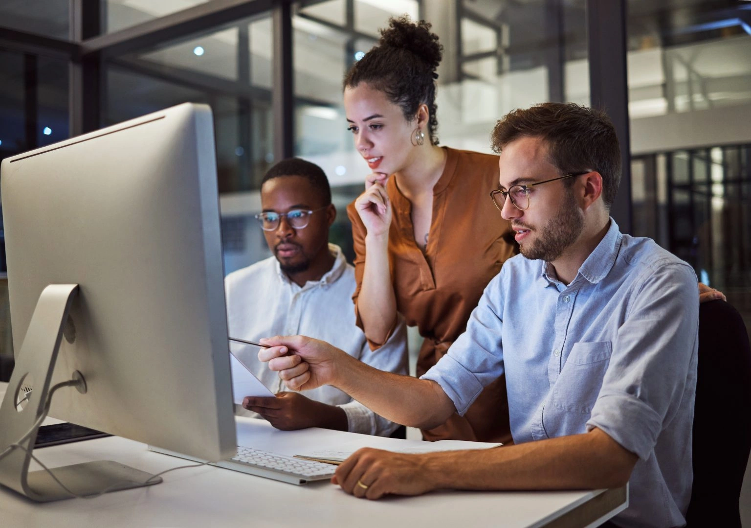 Team collaborating and looking at computer screen