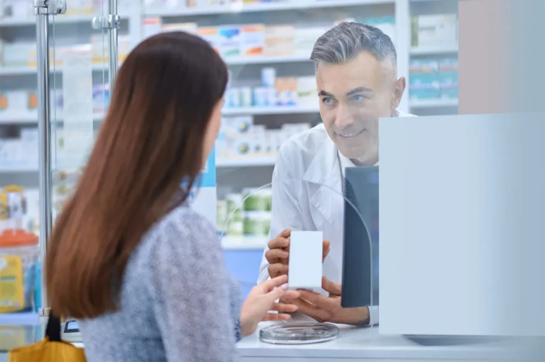 Pharmacist handing item to customer