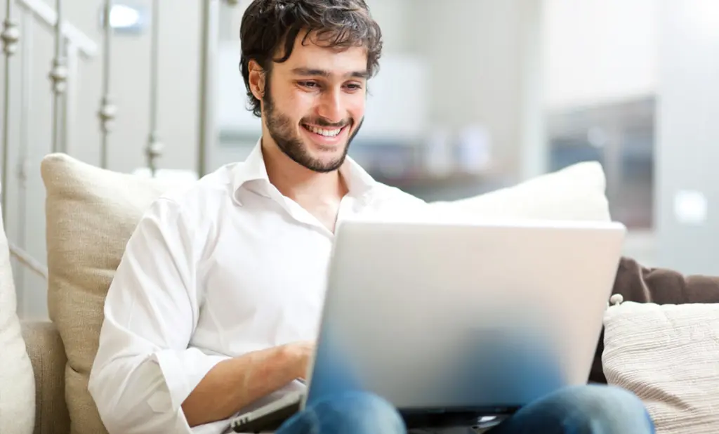 man smiling and using computer