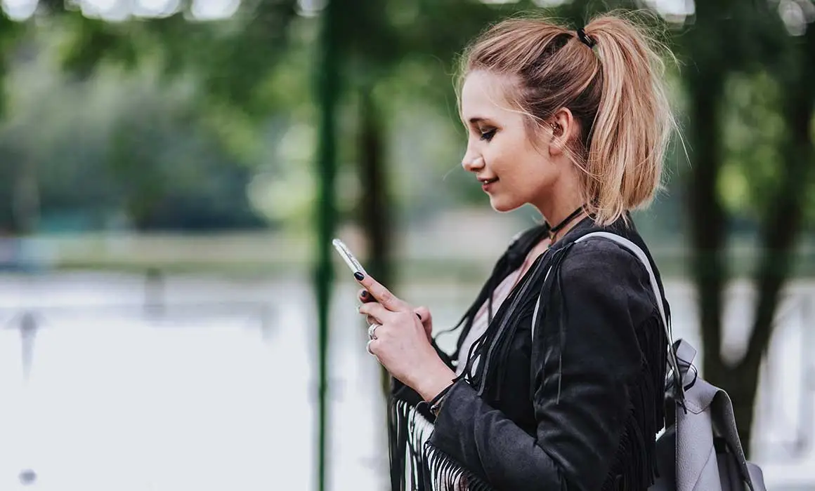 woman holding phone and looking at it