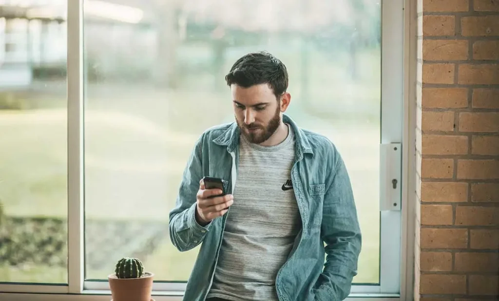 man holding phone and looking at it