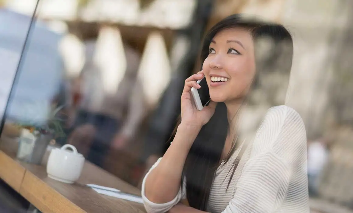 woman smiling and talking on phone