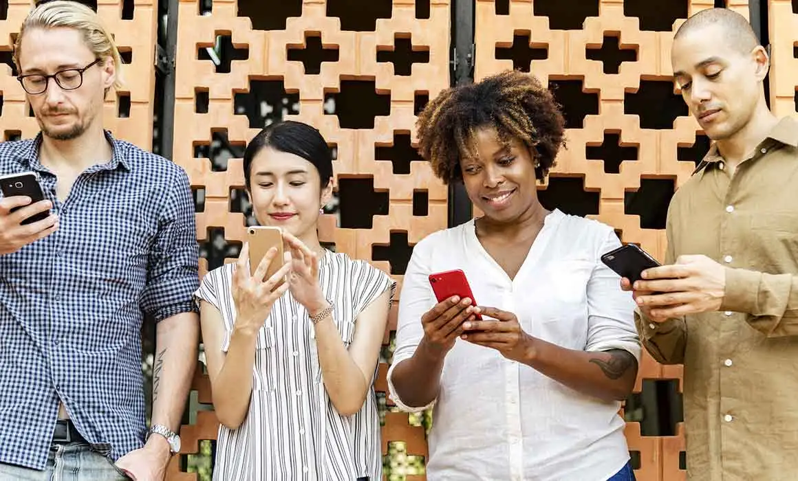 four people looking at their phones