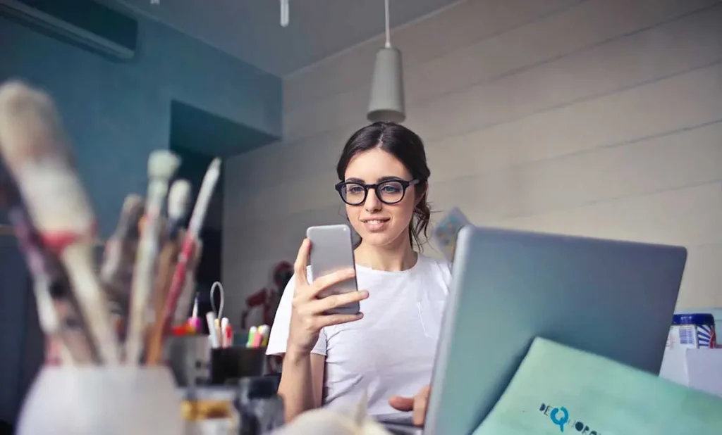 woman smiling and looking at phone