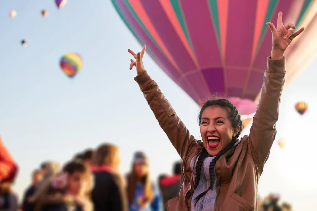 woman cheering at a hot air balloon festival