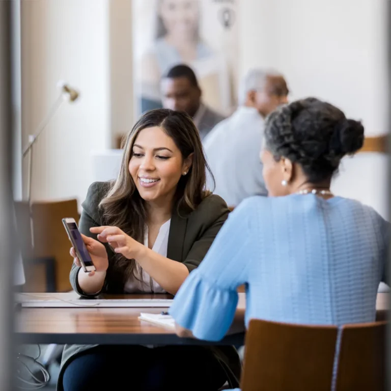 professional woman showing another woman something on her phone