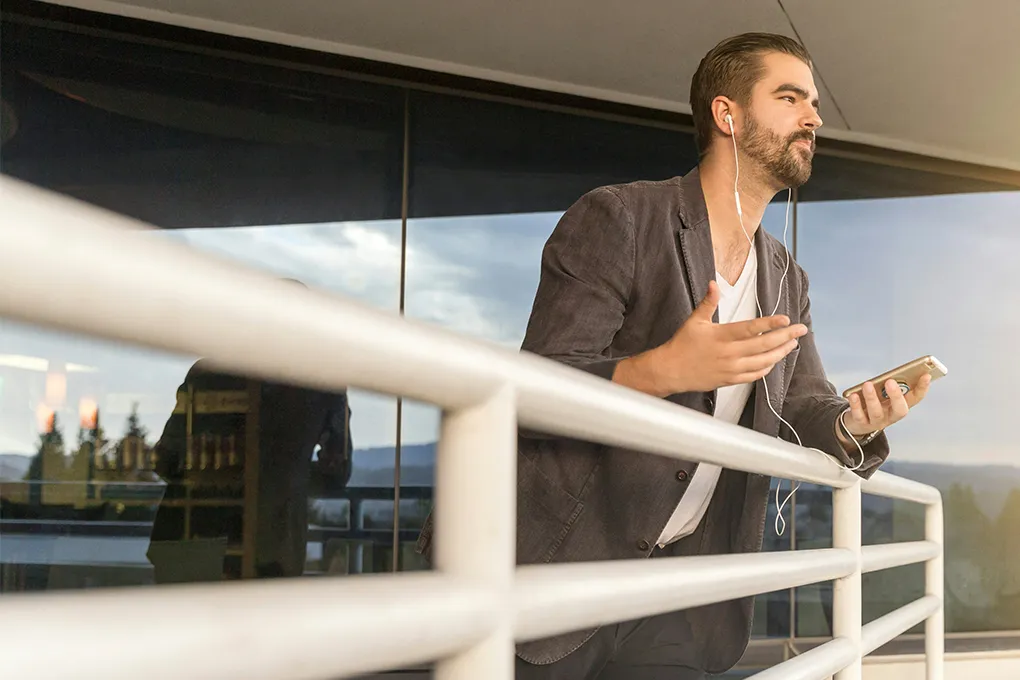 man with earbuds in talking on the phone